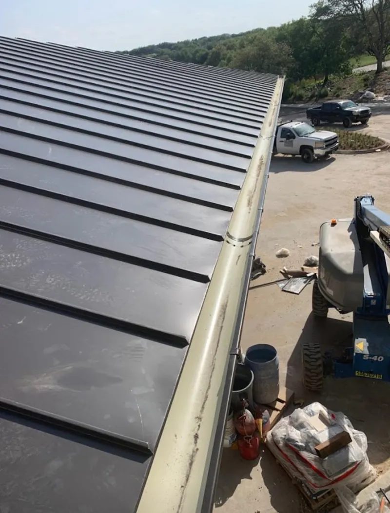 Standing seam panel and gutter detail on a metal roofing jobsite in Oxford